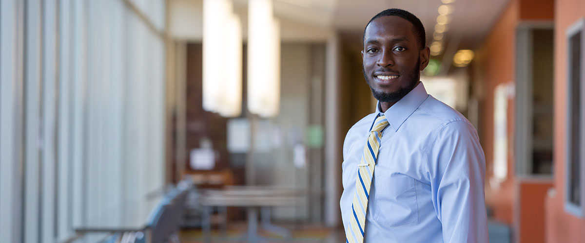 student standing in a building with a suite on
