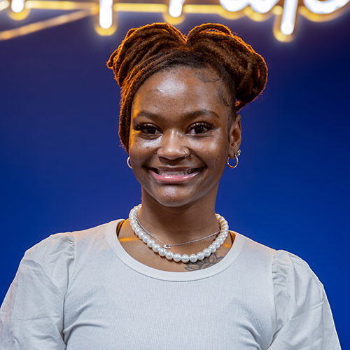 Image of Karmyn JordAn, wearing a white blouse and pearls