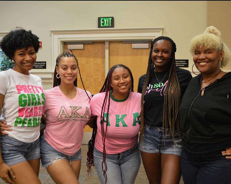 AKA group picture of five members, wearing street attire